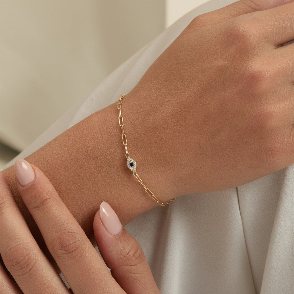 Lotus Diamond 14K gold paperclip bracelet with diamond and sapphire evil eye charm.